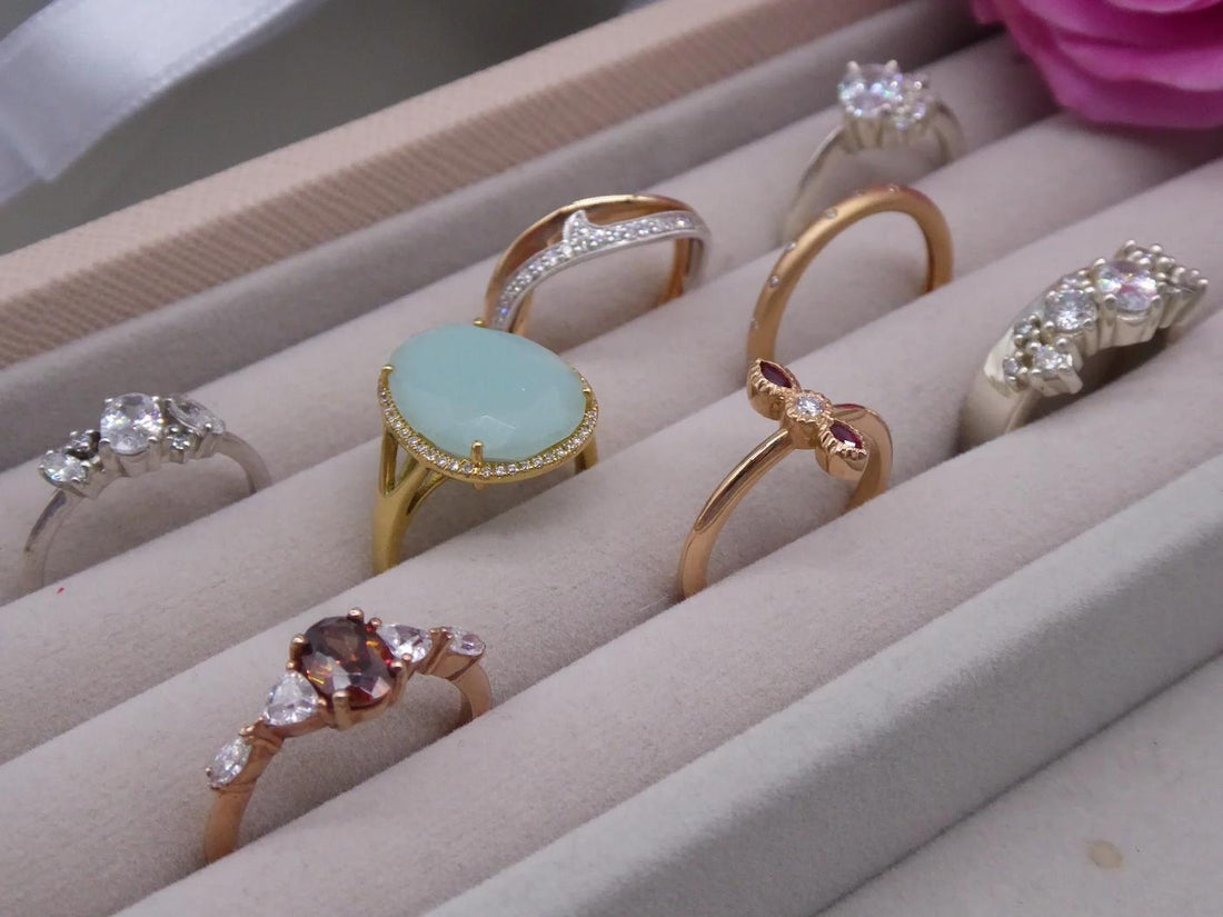 A selection of unique handmade engagement rings displayed on a velvet tray, handcrafted at Nude Jewellery London studio
