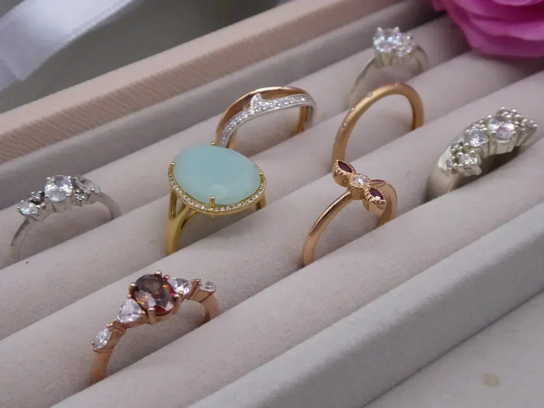 A selection of unique handmade engagement rings displayed on a velvet tray, handcrafted at Nude Jewellery London studio