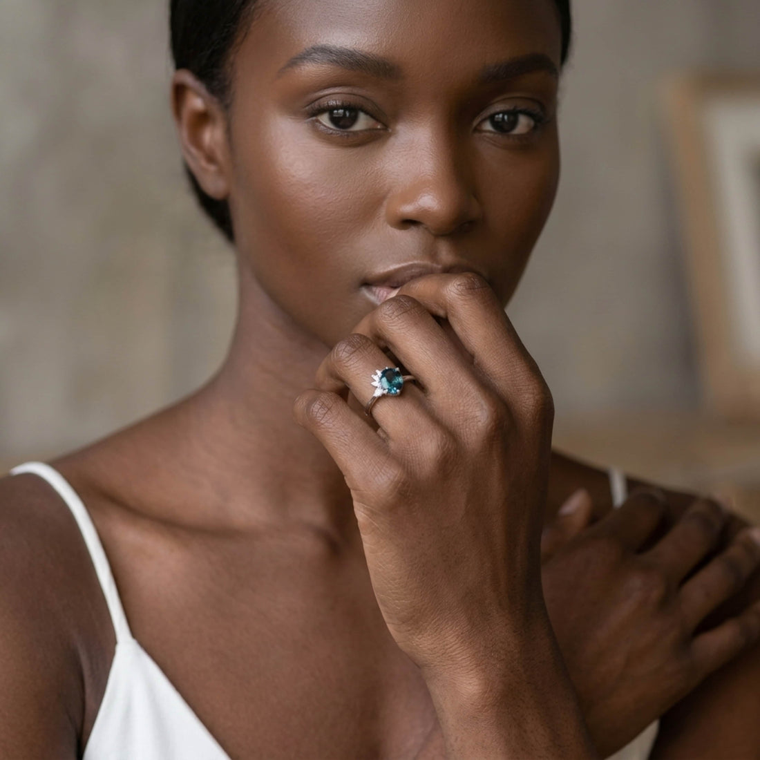The Selene teal sapphire and diamond asymmetrical engagement ring worn by a model