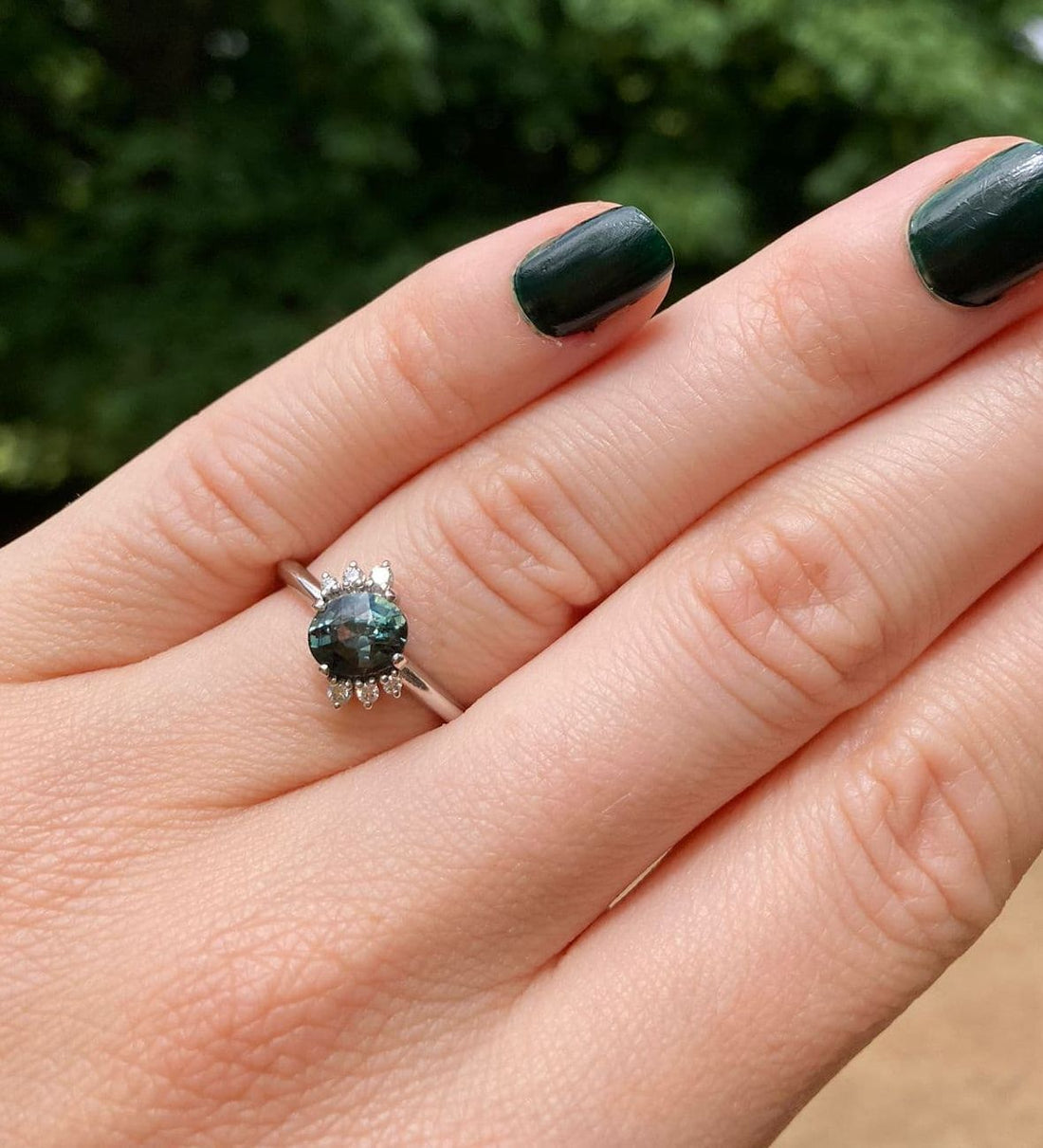 Selene teal sapphire and diamond cluster engagement ring worn on hand, handcrafted in our London studio by Nude Jewellery