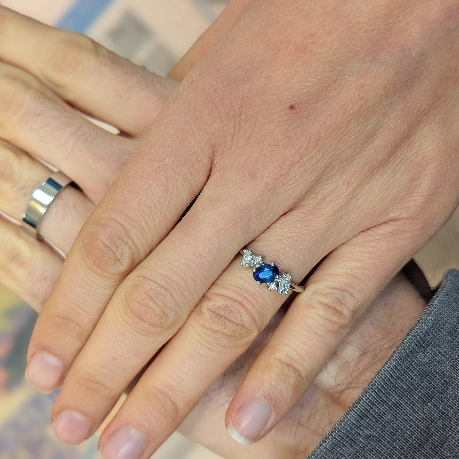 Client image of the Atlantis sapphire and diamond engagement ring being worn.