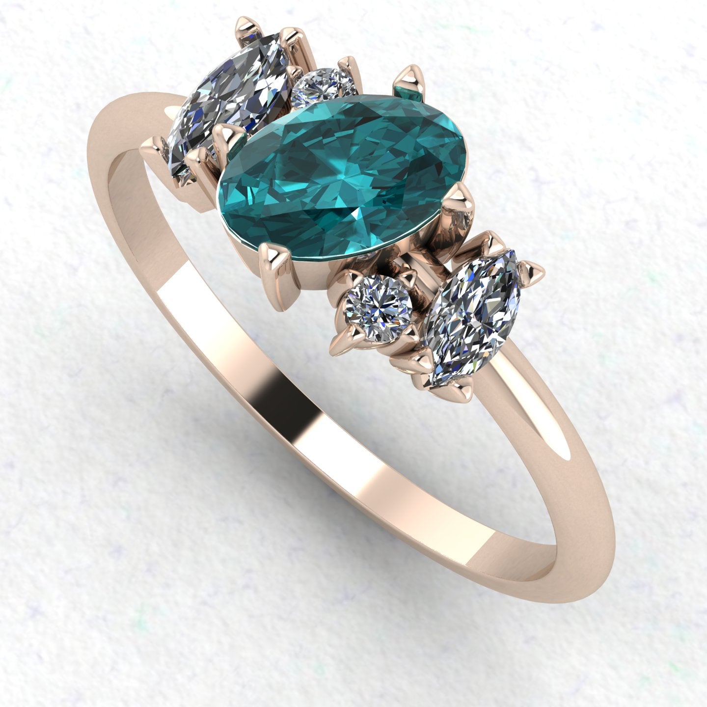 An angled perspective of the Atlantis teal sapphire ring, showcasing the handmade, contemporary design and the rich colour palette of the gemstones against the rose gold band.