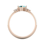 A view looking through the rose gold band, highlighting the thickness of the ring and the varying heights of the asymmetrical teal sapphire and diamond settings.