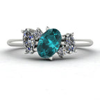 Front view of the Atlantis engagement ring, featuring an asymmetrical cluster of ocean-hued teal sapphires and brilliant diamonds set in platinum or white gold.