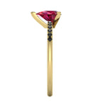 Side profile product photo of the Calista ring, displaying the clean, secure yellow gold three-prong basket setting holding the pear ruby.