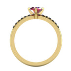 Through-finger view of the 18ct yellow gold ruby ring, showing the clean interior under-gallery and precise settings for the accent black diamonds.