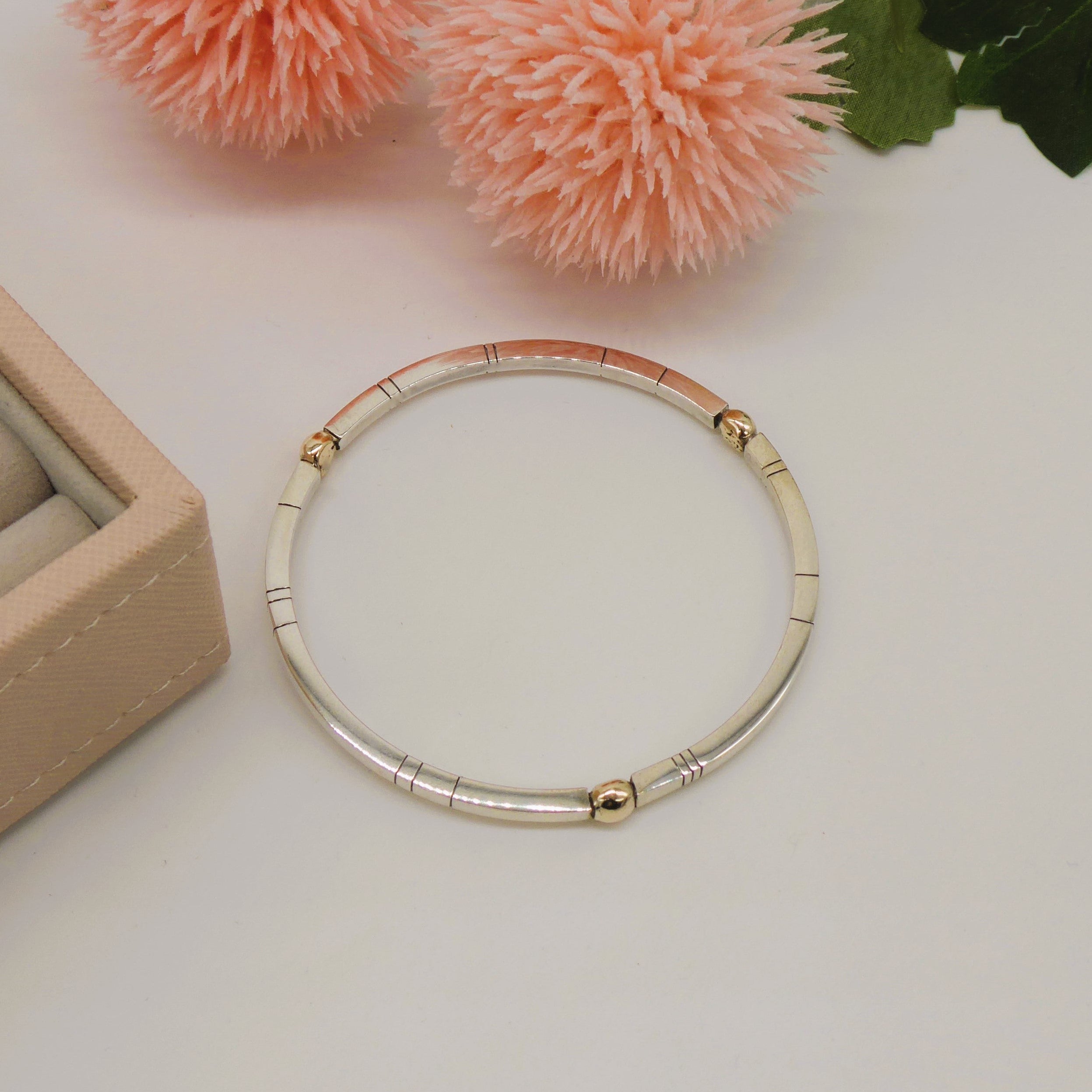 A top-down view of the Treble Solis square bangle, showing the contemporary geometric silhouette in polished recycled silver with three solid 9ct gold spheres set at regular intervals.