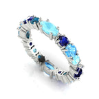 True Blue Allsorts eternity ring featuring natural blue sapphires, aquamarines, and topaz in a bespoke white gold band.