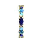 Side profile of the True Blue eternity band showing the yellow gold claw settings and the varying heights of the blue gemstones.