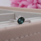 Selene oval teal sapphire and diamond asymmetric cluster engagement ring in 18ct white gold, presented in ring box showing the deep teal sapphire and diamond cluster, handmade in our London studio