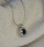 Angled view of the Alto Majestic pendant, featuring a round, brilliant-cut black spinel gemstone set within a high-polished recycled silver geometric frame.