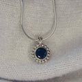 A front-facing view of the Alto Majestic pendant, featuring a round, brilliant-cut black spinel gemstone set within a high-polished recycled silver geometric frame.