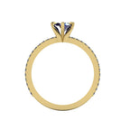 A through-finger view of the Amoret blue sapphire ring showing the internal yellow gold band and the clean setting symmetry.