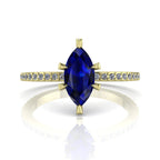 Profile view of the Amoret engagement ring in 18ct yellow gold showing the elegant silhouette of the marquise blue sapphire and diamond-set shoulders.