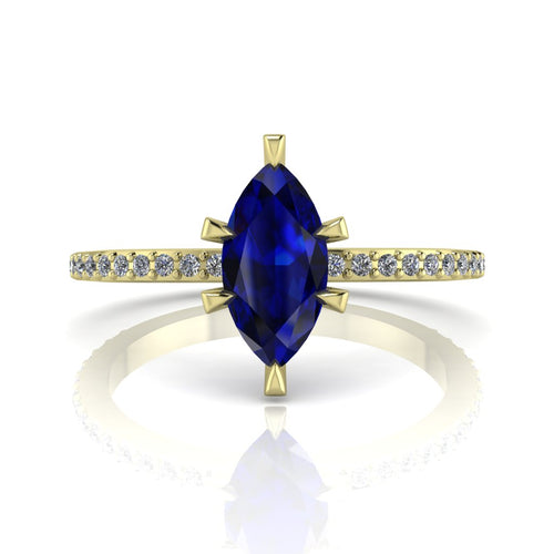 Profile view of the Amoret engagement ring in 18ct yellow gold showing the elegant silhouette of the marquise blue sapphire and diamond-set shoulders.