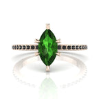Front profile view of the Amoret green tourmaline ring in 18ct rose gold showing the marquise silhouette and grain-set black diamond shoulders.