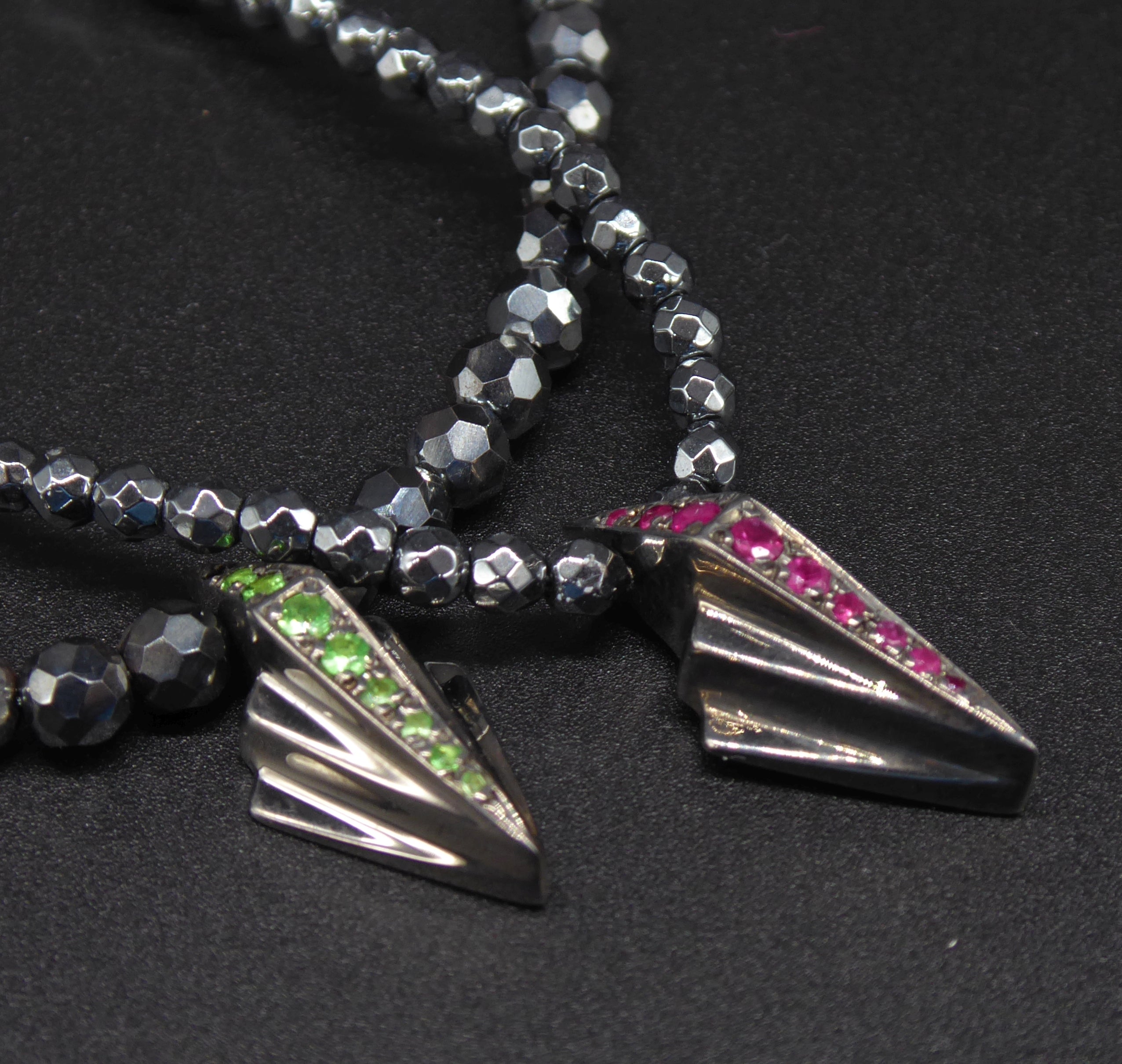 Front view of the silver Art Deco necklace featuring rubies and faceted hematite gemstone beads.