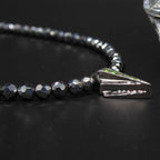 Close-up side view  of the green tsavorite garnet and the geometric silver Art Deco setting.