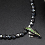 Front view of the Art Deco sterling silver pendant set with a green tsavorite garnet on a hematite gemstone necklace.