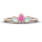 Front view of the Astraea Echo trilogy ring featuring an aquamarine centre and pink sapphire marquise shoulders in 18ct rose gold.