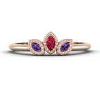 Front view of the Astraea Echo trilogy ring featuring a violet sapphire centre and ruby marquise shoulders in 18ct rose gold.