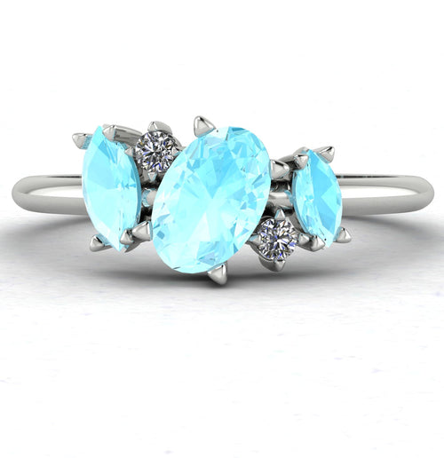 Front view of the Atlantis engagement ring, featuring an asymmetrical cluster of pale blue aquamarines and brilliant diamonds in a contemporary setting.
