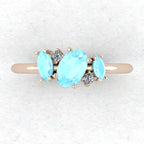 A top-down view of the Atlantis engagement ring, featuring an asymmetrical cluster of icy blue aquamarines and brilliant-cut diamonds in an 18ct rose gold setting.