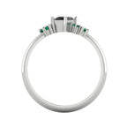 A view through the centre of the band, detailing the substantial thickness of the Platinum or white gold and the architectural height of the asymmetrical black diamond and emerald cluster.