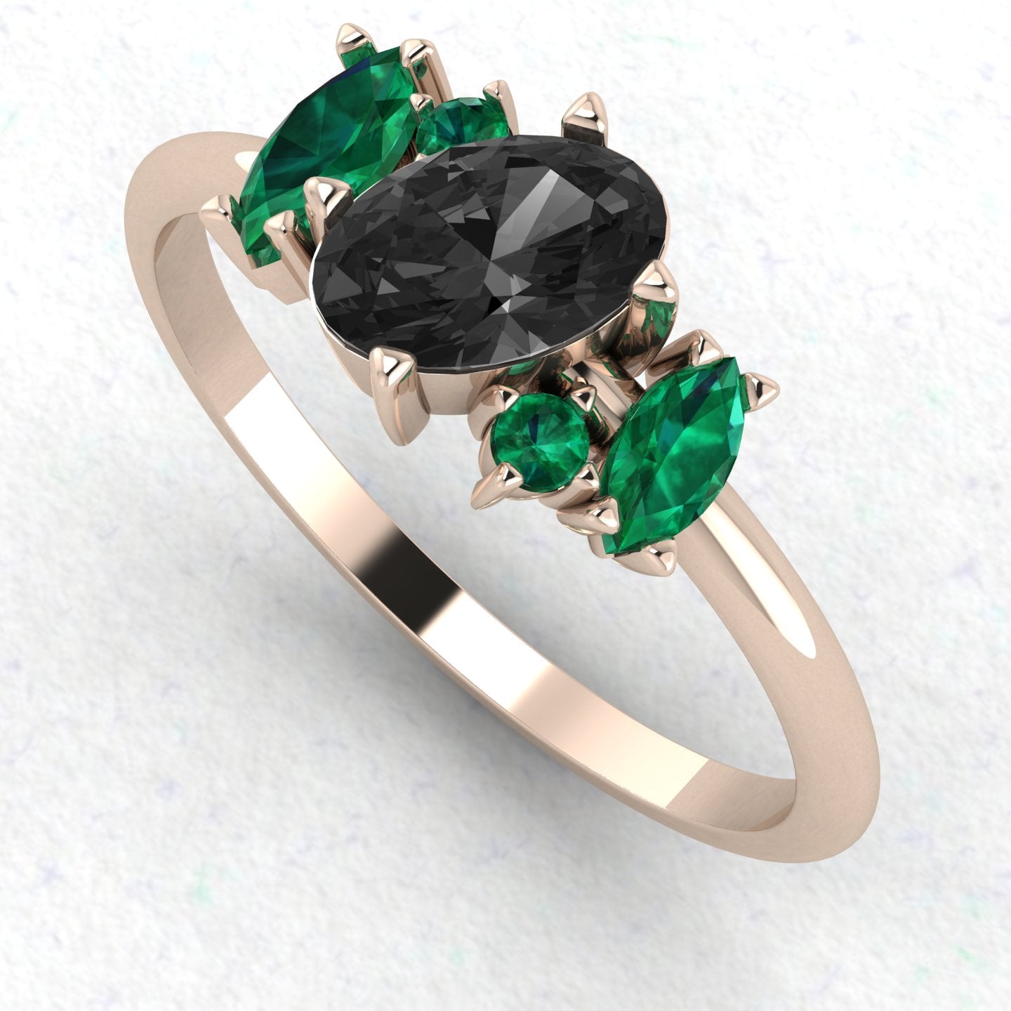 An angled perspective of the Atlantis ring, highlighting the dramatic contrast between the midnight-black diamond, lush green emeralds, and the warm tones of the handmade rose gold band.