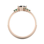 A view through the 18ct rose gold band, detailing the thickness of the ring and the precise, architectural arrangement of the asymmetrical black diamond and emerald settings.