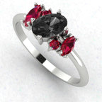 An angled perspective of the Atlantis ring, showcasing the contemporary organic design and the dramatic colour contrast between the black diamonds and red rubies.