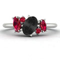 Front view of the Atlantis engagement ring featuring an asymmetrical cluster of striking black diamonds and vibrant red rubies in a white metal setting.