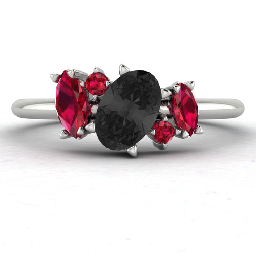 Front view of the Atlantis engagement ring featuring an asymmetrical cluster of striking black diamonds and vibrant red rubies in a white metal setting.