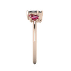 A side profile shot of the Atlantis asymmetrical ring, showcasing the handmade, textured settings and the unique elevations of the hand-set rubies and black diamond.