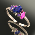 An angled perspective of the Atlantis ring, showcasing the organic design and the unique colour palette of blue sapphires against the rose gold band.