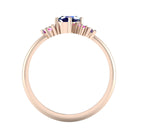 A view through the 18ct rose gold band, detailing the intricate under-gallery and the secure mounting of the blue rainbow sapphire stones.