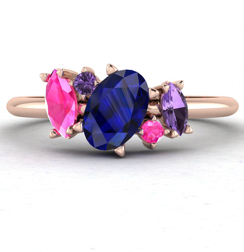 Front view of the Atlantis engagement ring, featuring an asymmetrical cluster of blue rainbow sapphires in various shades set in 18ct rose gold.