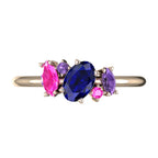 A top-down view of the Atlantis engagement ring, featuring an asymmetrical cluster of blue rainbow sapphires in various shades set in 18ct rose gold.