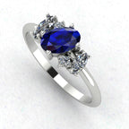 An angled perspective of the Atlantis ring, highlighting the contemporary organic design and the rich colour of the sapphires against the white metal band.