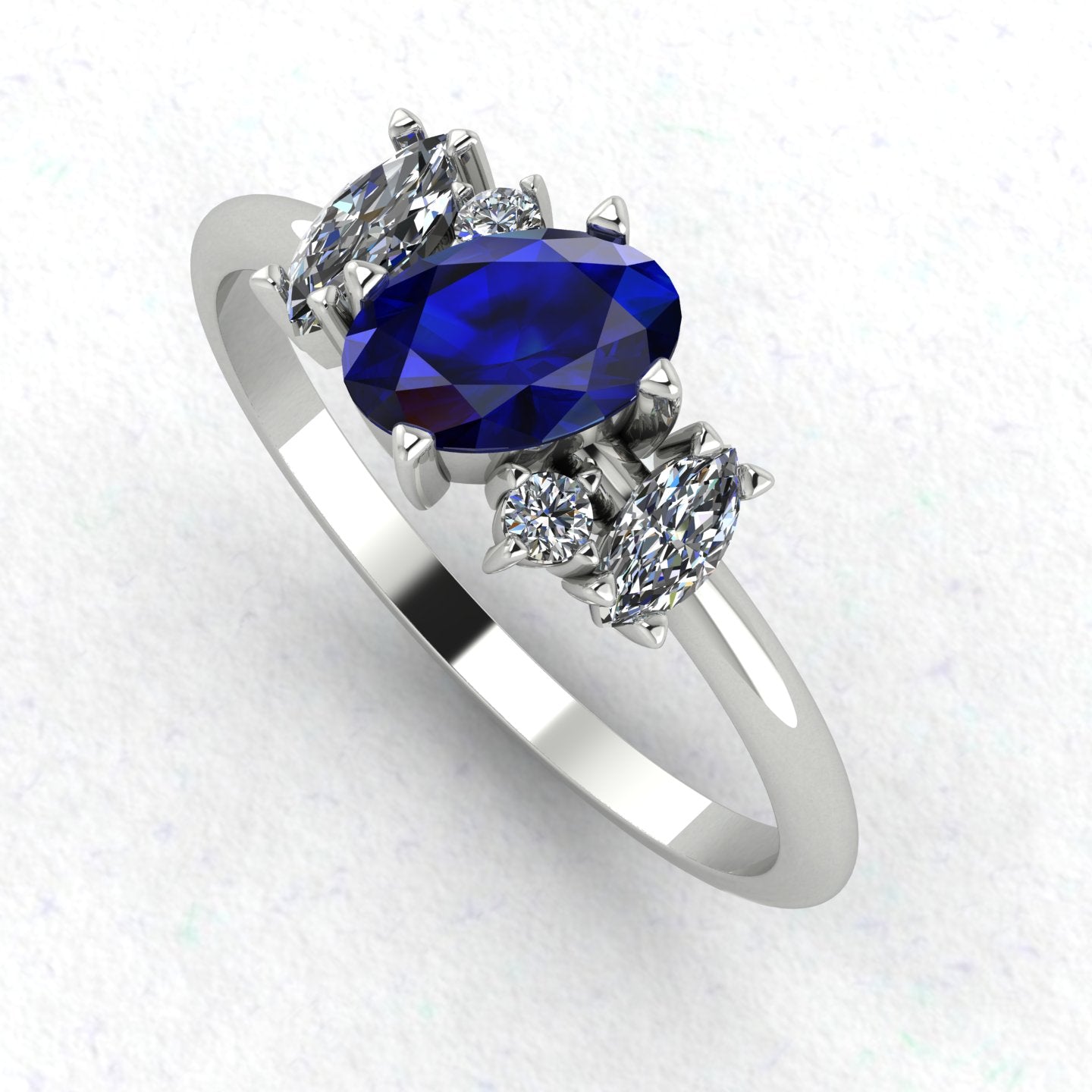 An angled perspective of the Atlantis ring, highlighting the contemporary organic design and the rich colour of the sapphires against the white metal band.