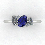 A top-down view of the Atlantis engagement ring, featuring an asymmetrical cluster of deep blue sapphires and sparkling diamonds set in white gold or platinum.