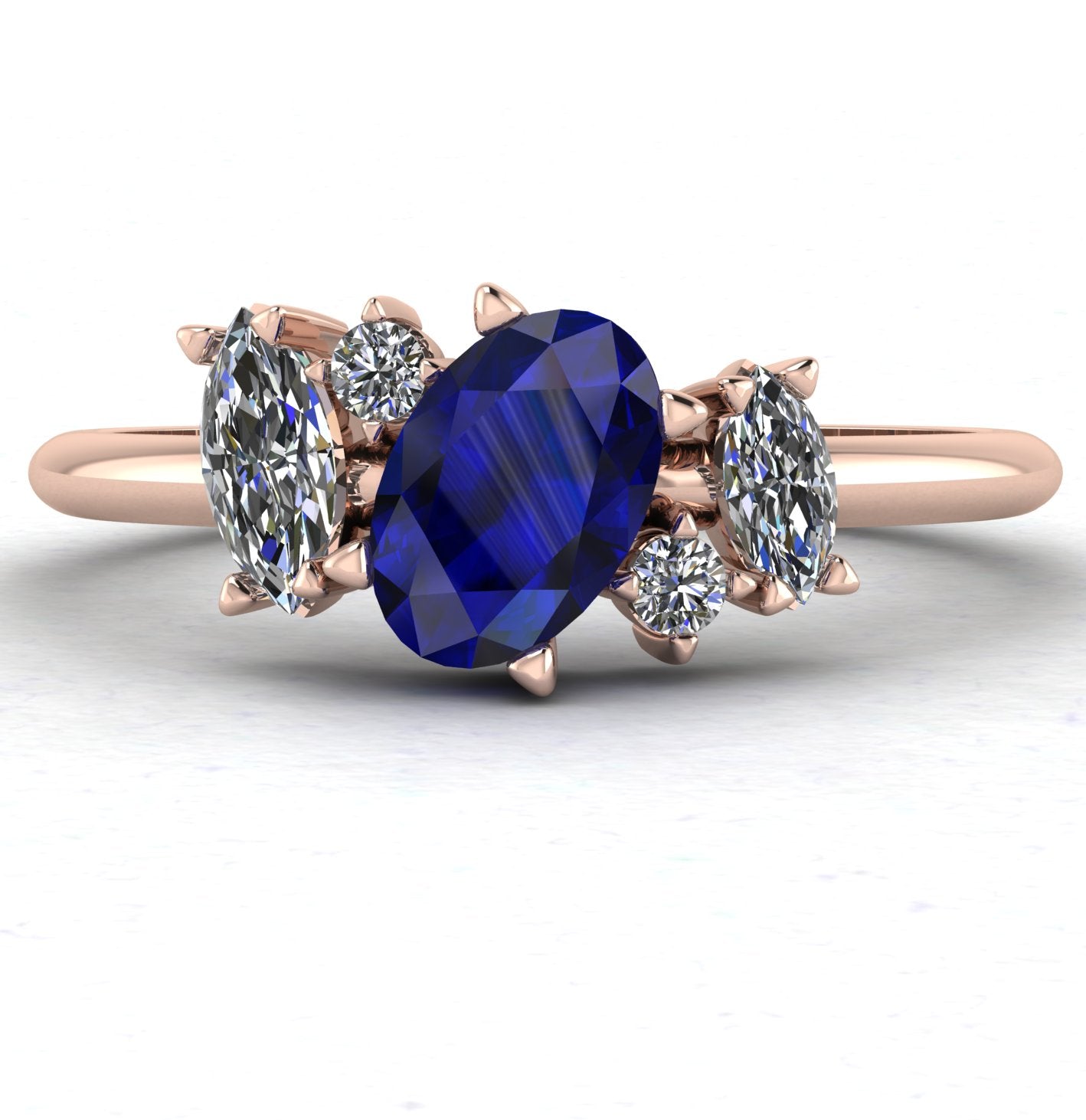 Front view of the Atlantis engagement ring, featuring a cluster of deep blue sapphires and sparkling diamonds in a bespoke asymmetrical 18ct rose gold setting.