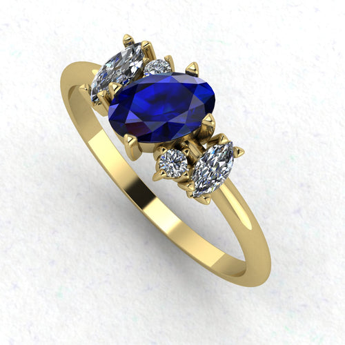 An angled perspective of the Atlantis ring, showcasing the organic, contemporary design and the rich contrast of blue sapphires against the warm yellow gold band.