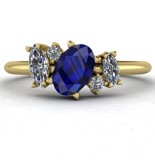 Front view of the Atlantis engagement ring, featuring an asymmetrical cluster of deep blue sapphires and brilliant diamonds set in 18ct yellow gold.