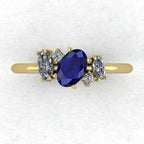 A top-down view of the Atlantis engagement ring, featuring an asymmetrical cluster of deep blue sapphires and brilliant diamonds set in 18ct yellow gold.