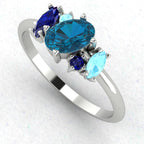 An angled perspective of the Atlantis ring, highlighting the organic design and the varying shades of blue from the topaz and aquamarine stones.