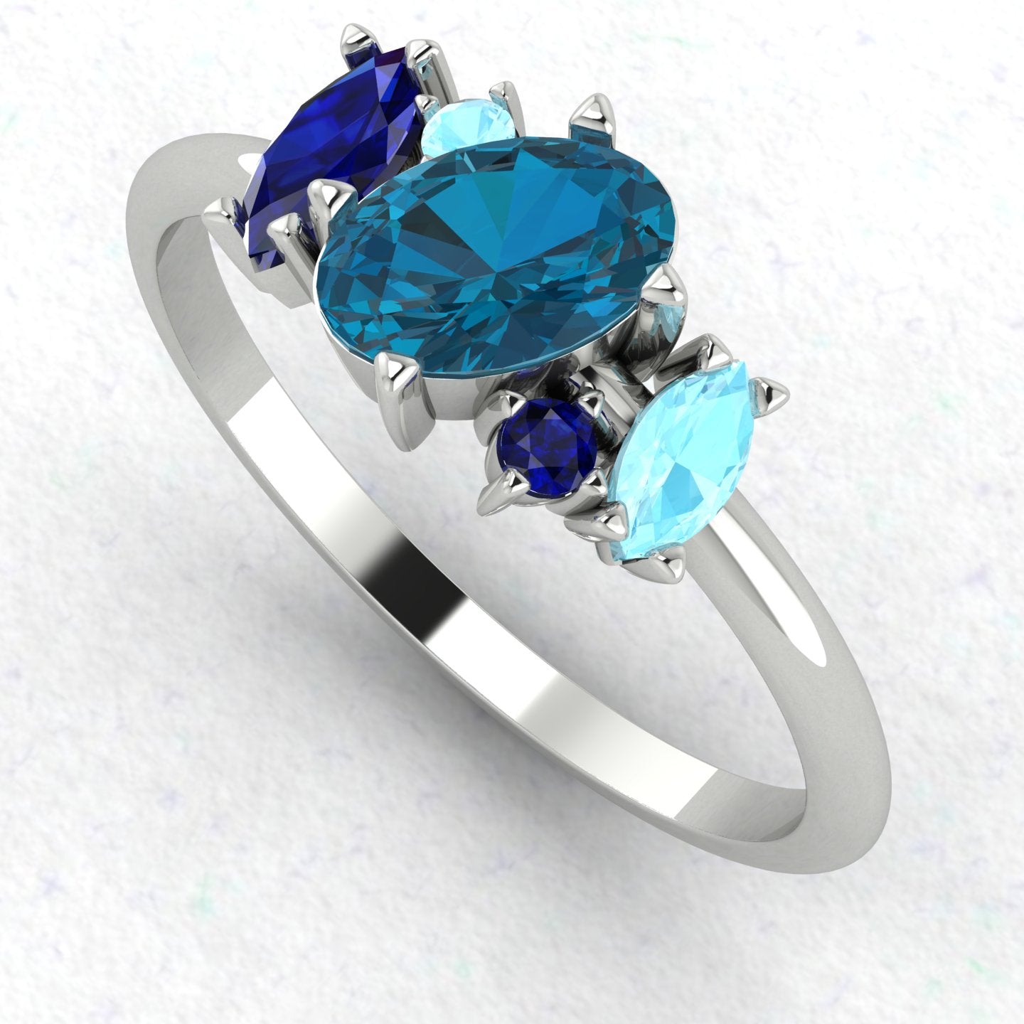 An angled perspective of the Atlantis ring, highlighting the organic design and the varying shades of blue from the topaz and aquamarine stones.