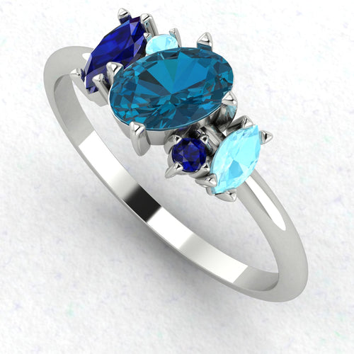 An angled perspective of the Atlantis ring, highlighting the organic design and the varying shades of blue from the topaz and aquamarine stones.