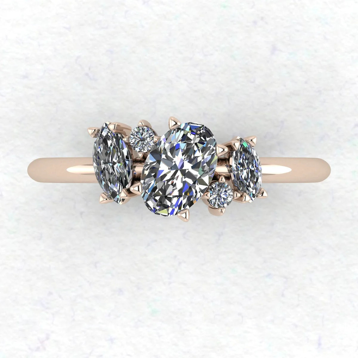 Top-down view of Atlantis asymmetrical diamond engagement ring in 18ct rose gold showing oval centre with flanking marquise diamonds