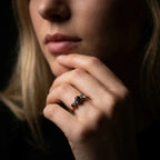 Atlantis London blue topaz and sapphire asymmetrical engagement ring worn on hand in 18ct rose gold, showing the scale and light reflection of the blue gemstones, handmade in our London studio